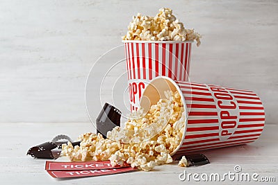 Popcorn, tickets and film footage on wooden table. Cinema snack Stock Photo
