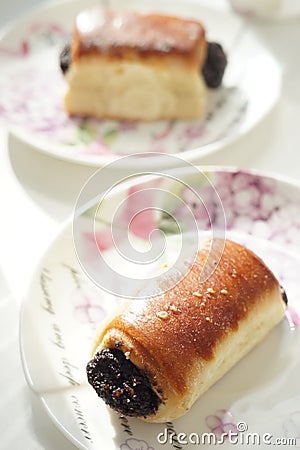 Poppy buns in white romantic saucers on a table Stock Photo