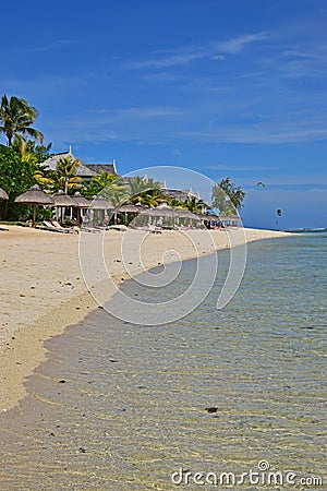 Popular Beach Resort at Le Morne, Mauritius with waving palm trees and sunbathing hut and very clear water Editorial Stock Photo