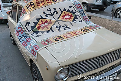 Armenia, Yerevan, September 2021. A vintage car covered with an old carpet. Editorial Stock Photo