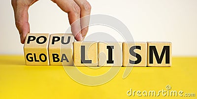 Populism or globalism. Hand turns cubes and changes word `globalism` to `populism`. Beautiful yellow table, white background, Stock Photo