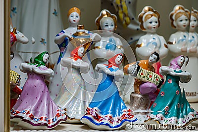 Assortment of rare porcelain figurines on glass shelf Stock Photo