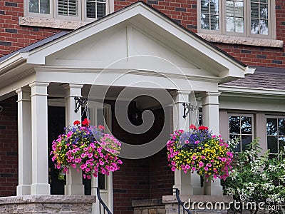 Porch with hanging baskets of flowers Stock Photo