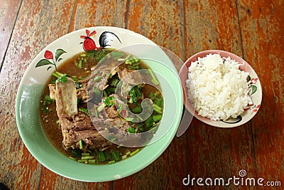 Pork backbone sour soup and rice on wood table. Stock Photo