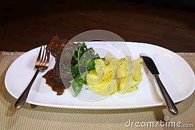 Pork cheeks in Demiglas sauce with boiled potatoes. Stock Photo