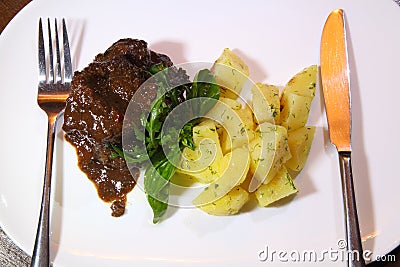 Pork cheeks in Demiglas sauce with boiled potatoes. Stock Photo