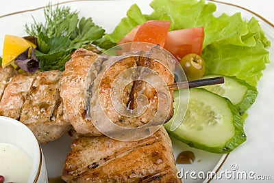 Pork (or chicken) on grill spit with salad Stock Photo