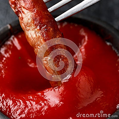 Pork Chipolata sausages dipping in ketchup sauce Stock Photo