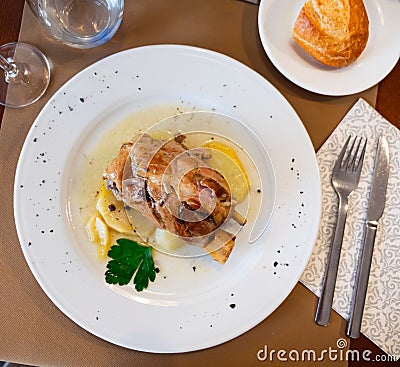 Pork knuckle baked in oven with boiled potatoes in white plate Stock Photo