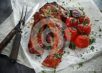 Pork middle chop roast with sweet and sour souce, baked tomatoes and red onion Stock Photo