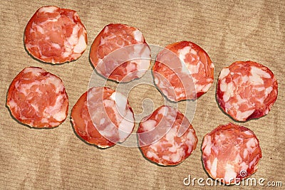 Pork Salami Slices On Crumpled Striped Manila Brown Kraft Paper Stock Photo