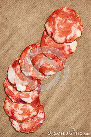 Pork Salami Slices On Crumpled Striped Manila Brown Kraft Paper Stock Photo