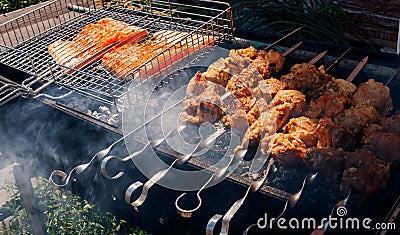 Pork and salmon kebabs grilling outside Stock Photo