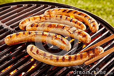 Pork sausages grilling on a portable BBQ Stock Photo