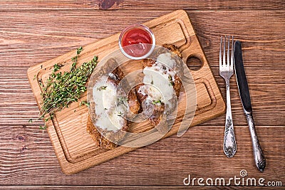 Pork schnitzel with sauce on the wooden board. Stock Photo