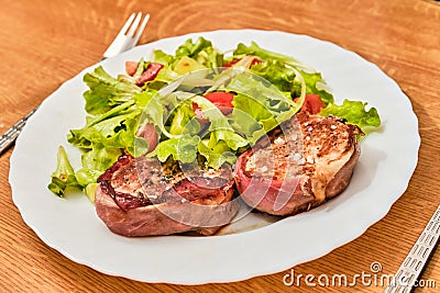 Pork tenderloin in dried ham steak with salad Stock Photo