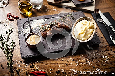 Pork tenderloin with mashed potatos, bacon and mustard sauce with branch of smoking rosemary. Delicious healthy Stock Photo
