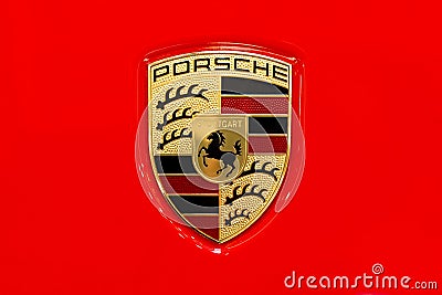 Porsche car brand logo on a shiny red car hood closeup, macro, detail, top view, classic Porsche AG Stuttgard company emblem Editorial Stock Photo
