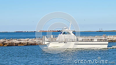 PORT ARANSAS, TX - 27 FEB 2020: Jetty boat leaves the marina entrance Editorial Stock Photo