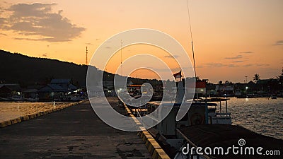 A port deck small on the remote island on sunrise with black shadow and orange sky Stock Photo