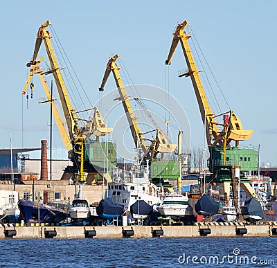 Cranes and boats on the harbor quay Stock Photo
