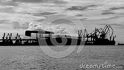 Port silhouette with calm water and clear sky on Morowali beach Stock Photo