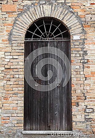 Parete di pietra antica con la porta di legno dell'arco fotografia ...