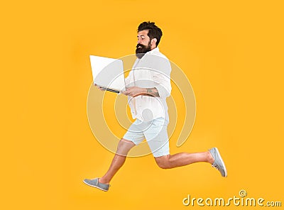Portability concept. Remote job. Man inspired hold laptop jump. Run with laptop. Hipster bearded manager with laptop Stock Photo