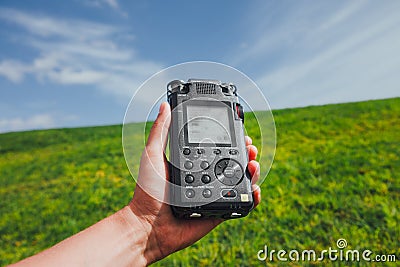 Portable audio recorder in hand field recording ambient sounds of nature Stock Photo