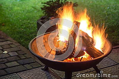 A portable fireplace with bright burning firewoods making sparks Stock Photo