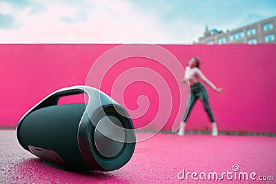 Portable speaker for playing music, product presentation on outdoor dance floor. Advertising of wireless audio device Stock Photo