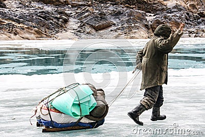 Porter Crossing Frozen Zanskar River. Chadar Trek Stock Photo