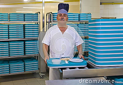 Porter With Plastic Trays In Hospital Kitchen Stock Photo