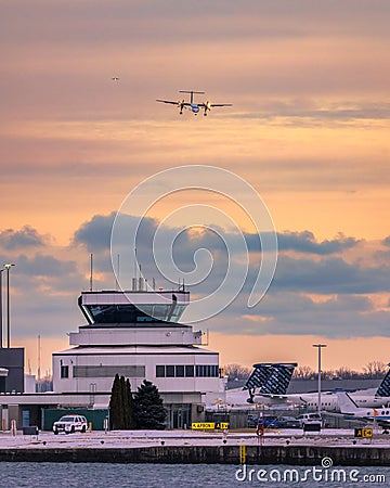 Porter propellor airplane on approach to Billy Bishop Airport at sunset. De Havilland Canada Dash 8 Q400 Editorial Stock Photo