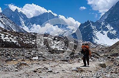 Porters carry heavy load in the Himalaya Editorial Stock Photo
