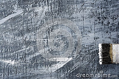 Portion of the brush in black and white paint on the background of a concrete painted gray background on the right bottom Stock Photo