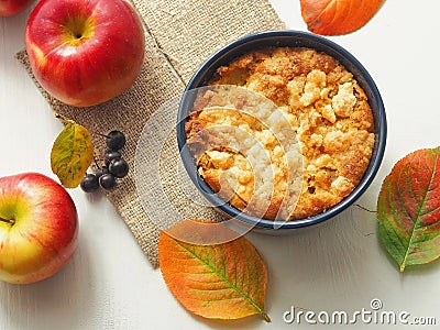 Portion of coffeecake in blue bowl. Biscuit with autumn apples. Homemade crumble pie with streusel topping. Stock Photo