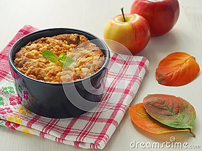 Portion of coffeecake in blue mug. Biscuit with autumn apples. Homemade crumble pie with streusel topping. Stock Photo