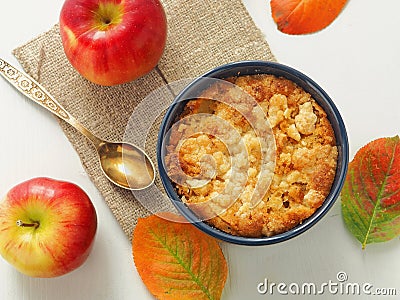 Portion of coffeecake in blue mug. Biscuit with autumn apples. Homemade crumble pie with streusel topping. Stock Photo