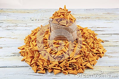 Portion of cone shaped snack tornado shaped crackers. Yellow spicy potato cone chips texture or Background of corn cone Stock Photo