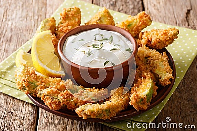 Portion of deep-fried golden avocado in breading with sauce and Stock Photo