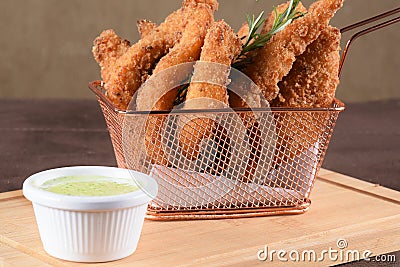 portion of fried fish, fried chicken strips inside metal basket tasty snack Stock Photo