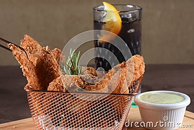 portion of fried fish, fried chicken strips inside metal basket tasty snack Stock Photo