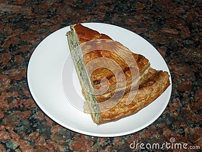 A portion of a healthy vegetable pie on a white plate with a dark background of brown granite Stock Photo