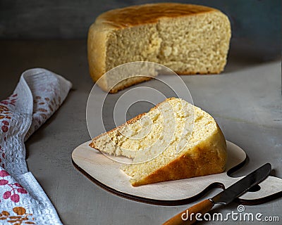 Portion of homemade grain on a kitchen board and round bread in a cut on a wooden table Stock Photo