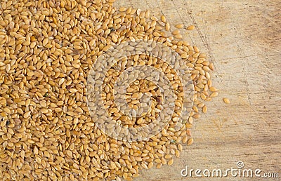 Portion of organic golden flaxseed spilled on a cutting board Stock Photo