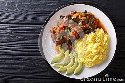 Portion of seco de chivo stewed goat meat with yellow rice and a Stock Photo