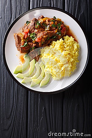 Portion of seco de chivo stewed goat meat with yellow rice and a Stock Photo