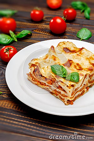 Portion of tasty lasagna on wooden backgound Stock Photo