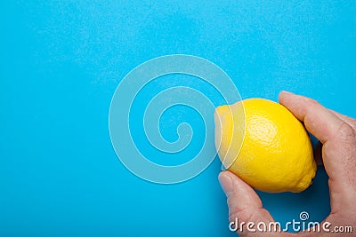 Portion of vitamins in the hand - yellow lemon on a blue background Stock Photo